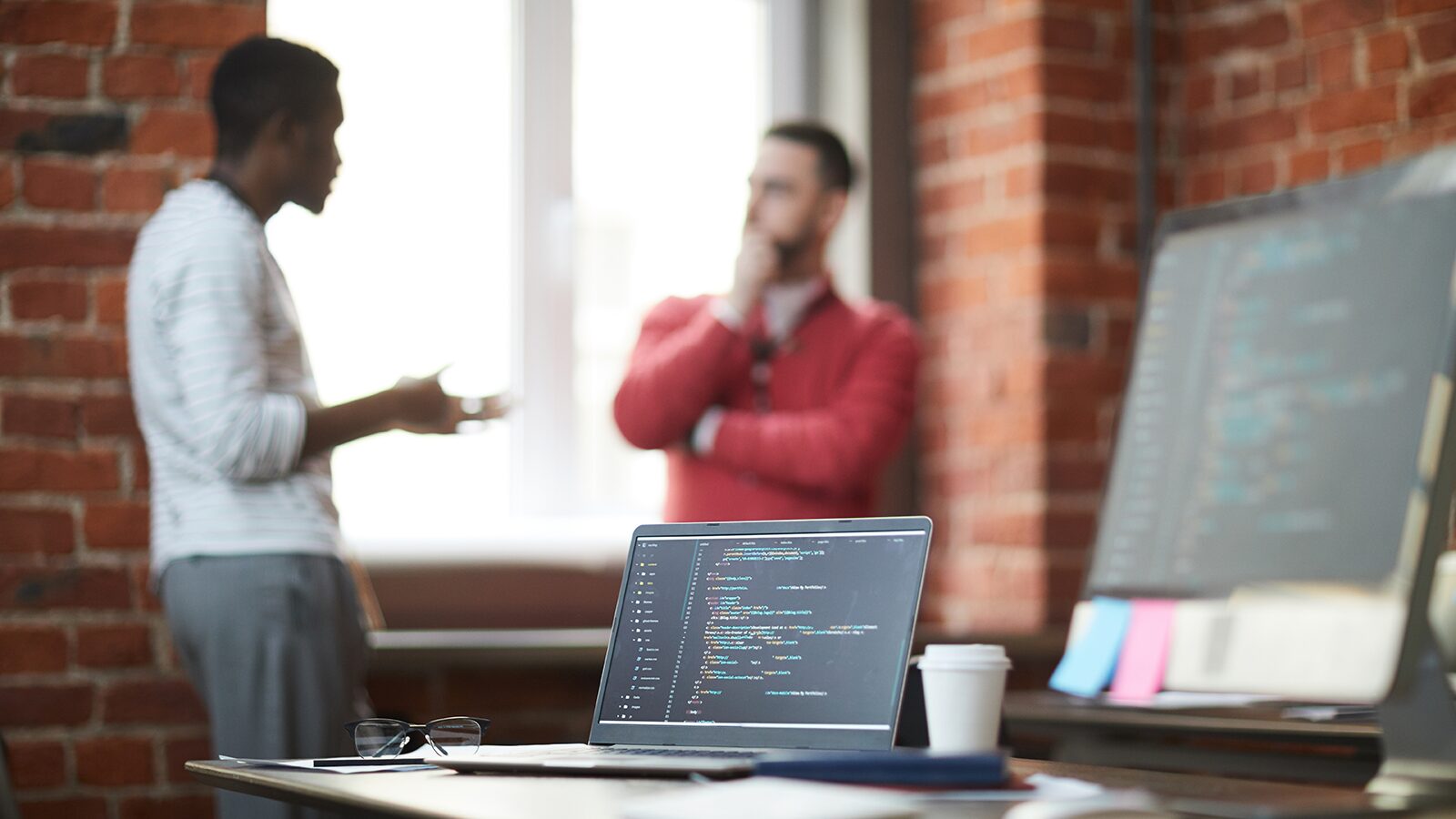 IT professionals discussing software code in an office
